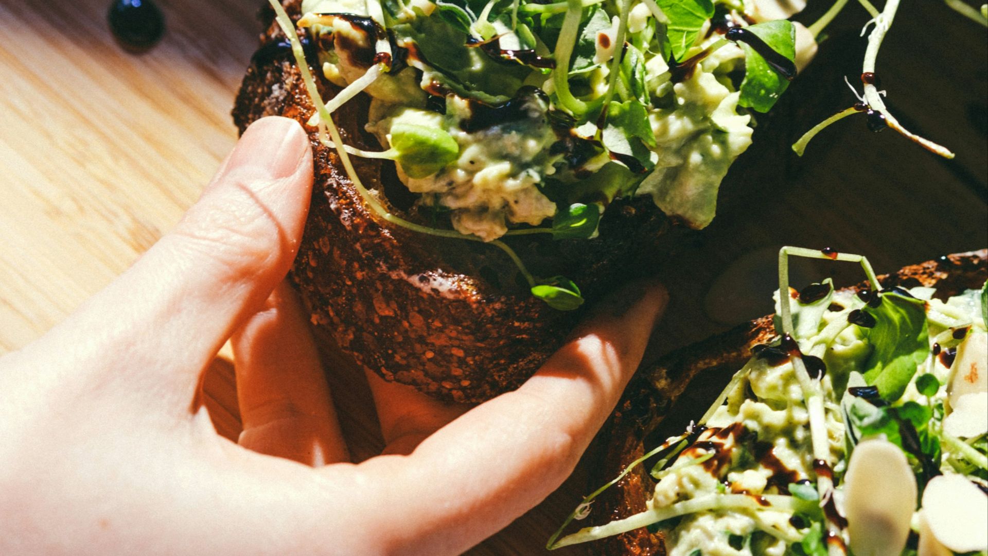 a person holding a sandwich in their hand