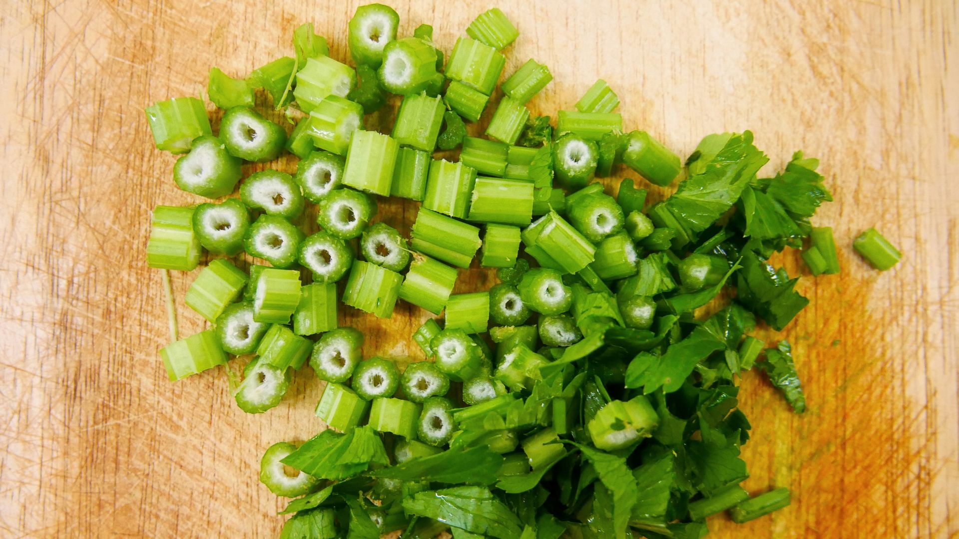 chopped up green vegetables on a cutting board