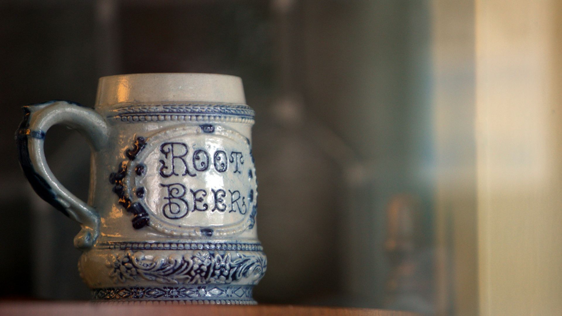 a beer mug sitting on top of a wooden shelf