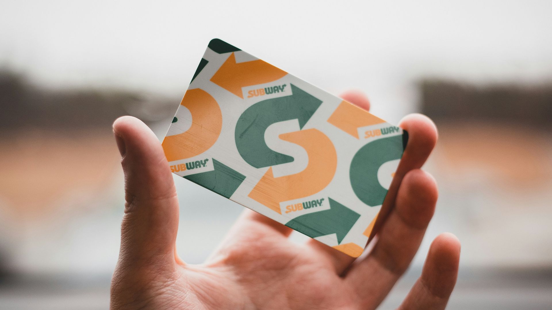 person holding green and white card