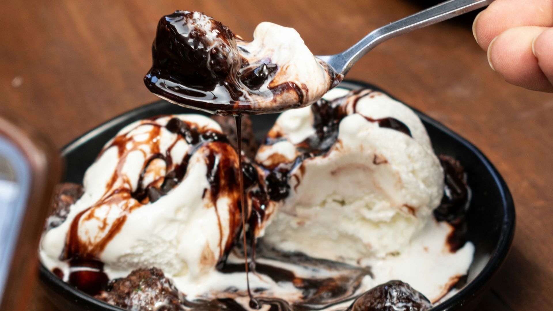 ice cream with chocolate syrup on brown wooden table