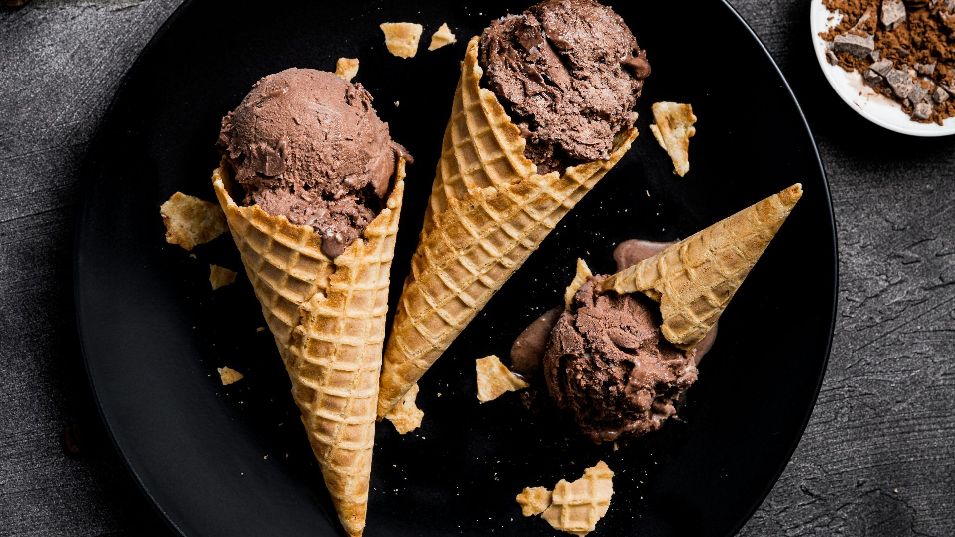 waffle with chocolate ice cream on black round plate