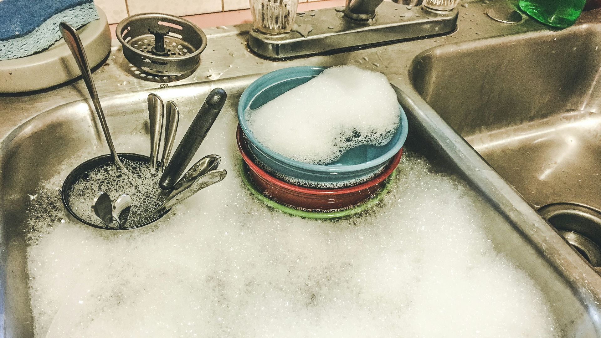 stainless steel spoons on white ceramic sink