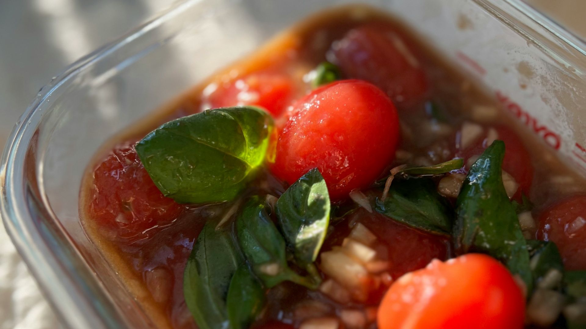 a plastic container filled with tomatoes and other vegetables