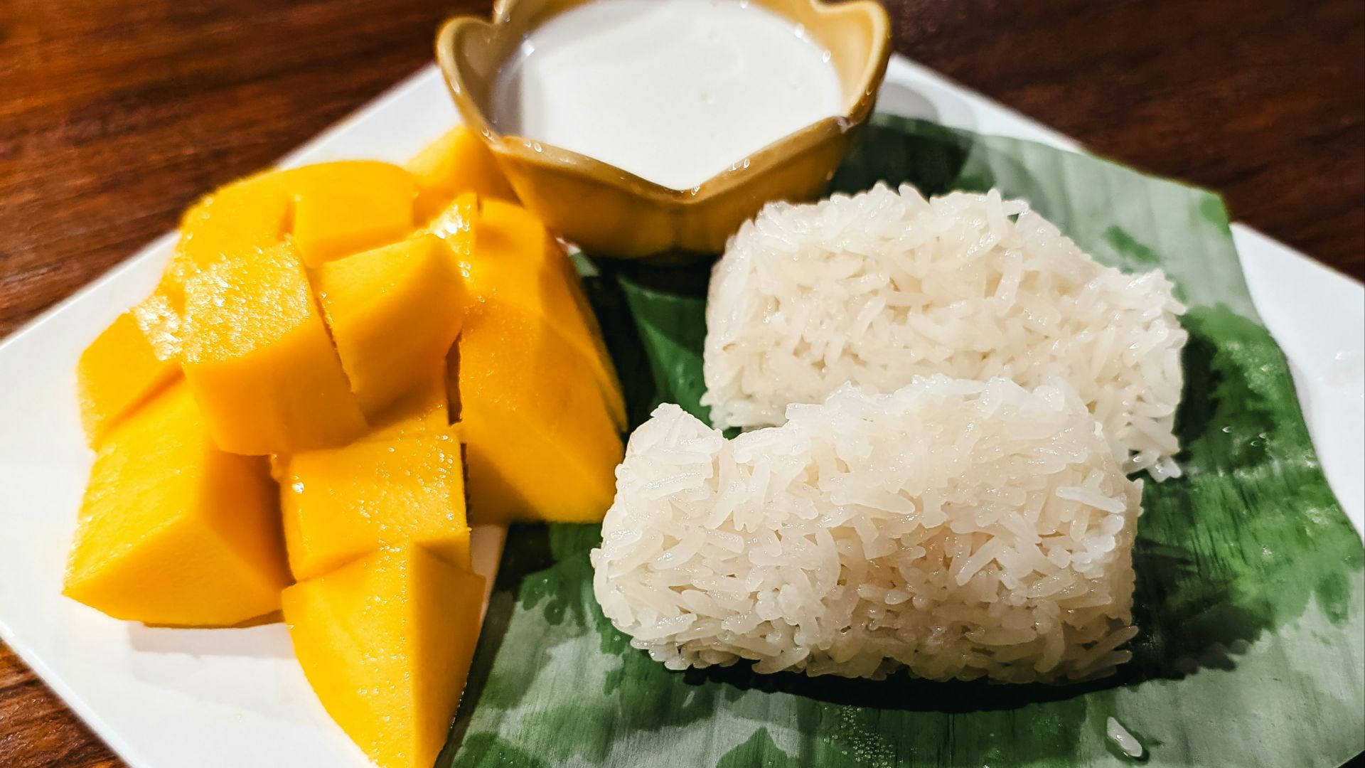 a plate of food with rice, mango and sauce