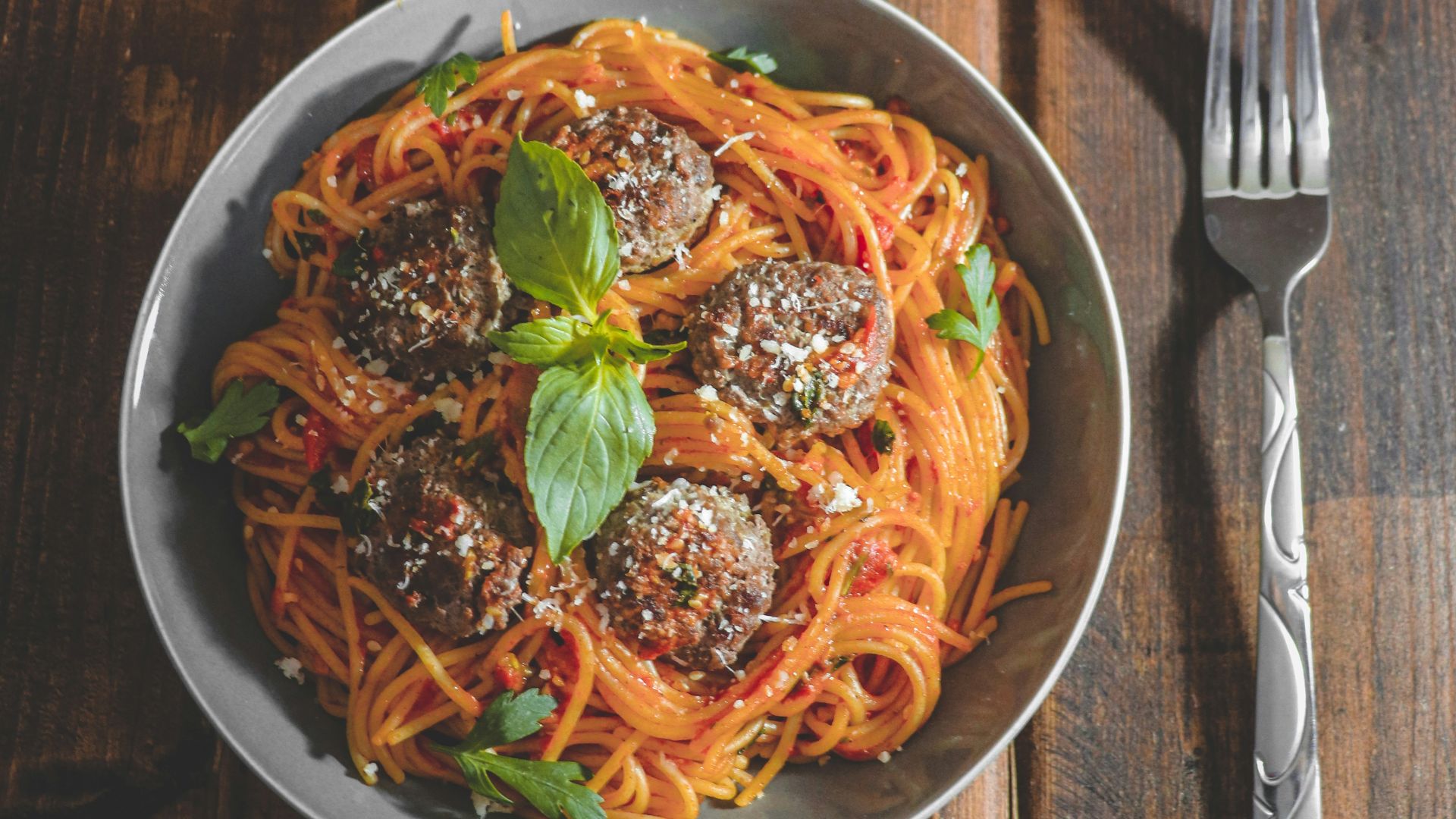 a plate of spaghetti with meatballs and tomatoes