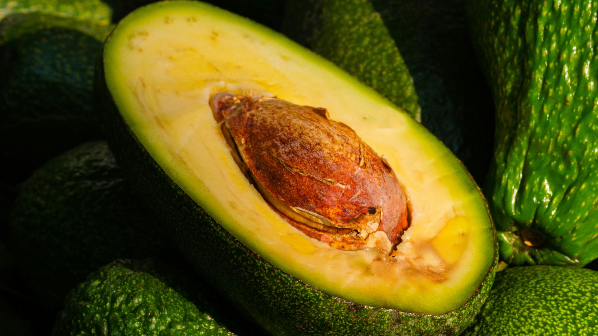 a pile of green avocados sitting on top of each other