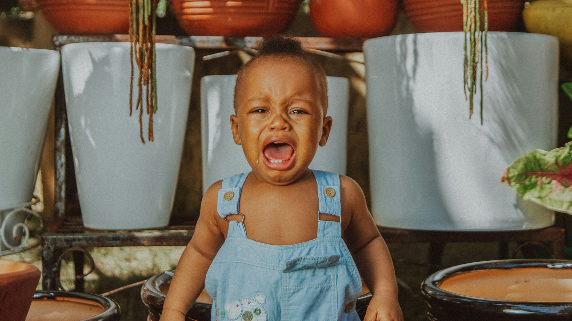 girl in blue tank top standing beside brown woven basket
