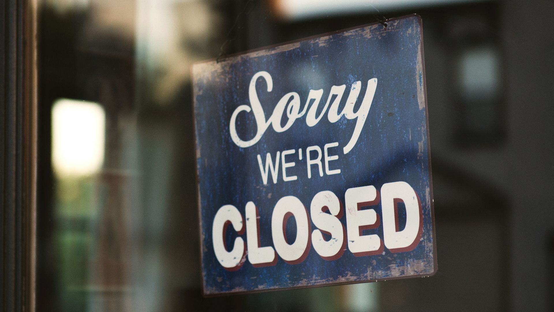 Sorry we're closed signage hanged on glass door