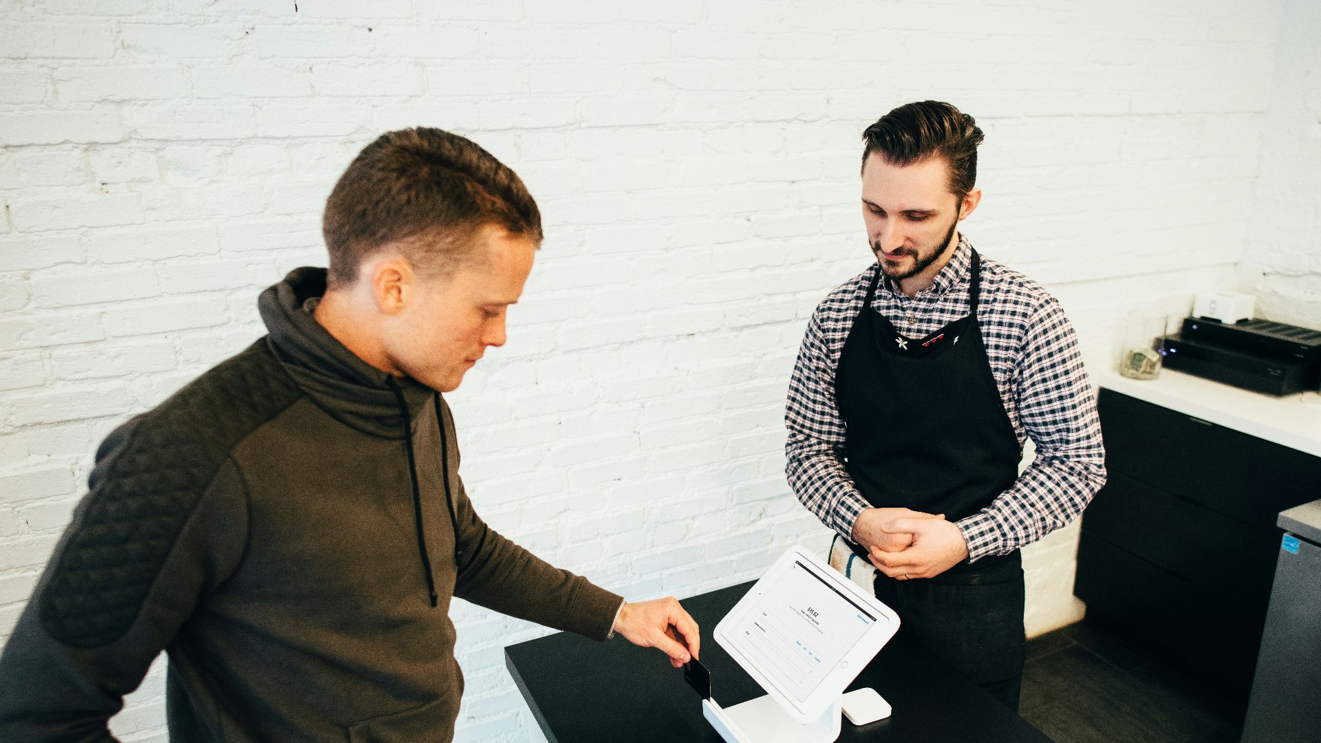 man looking at white digital device