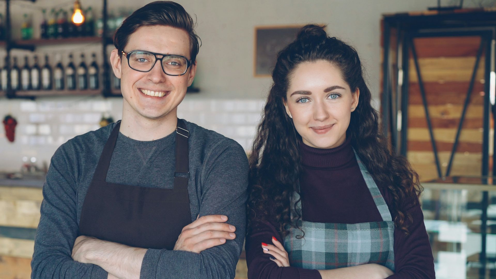 Two cafe owners proudly stand together.