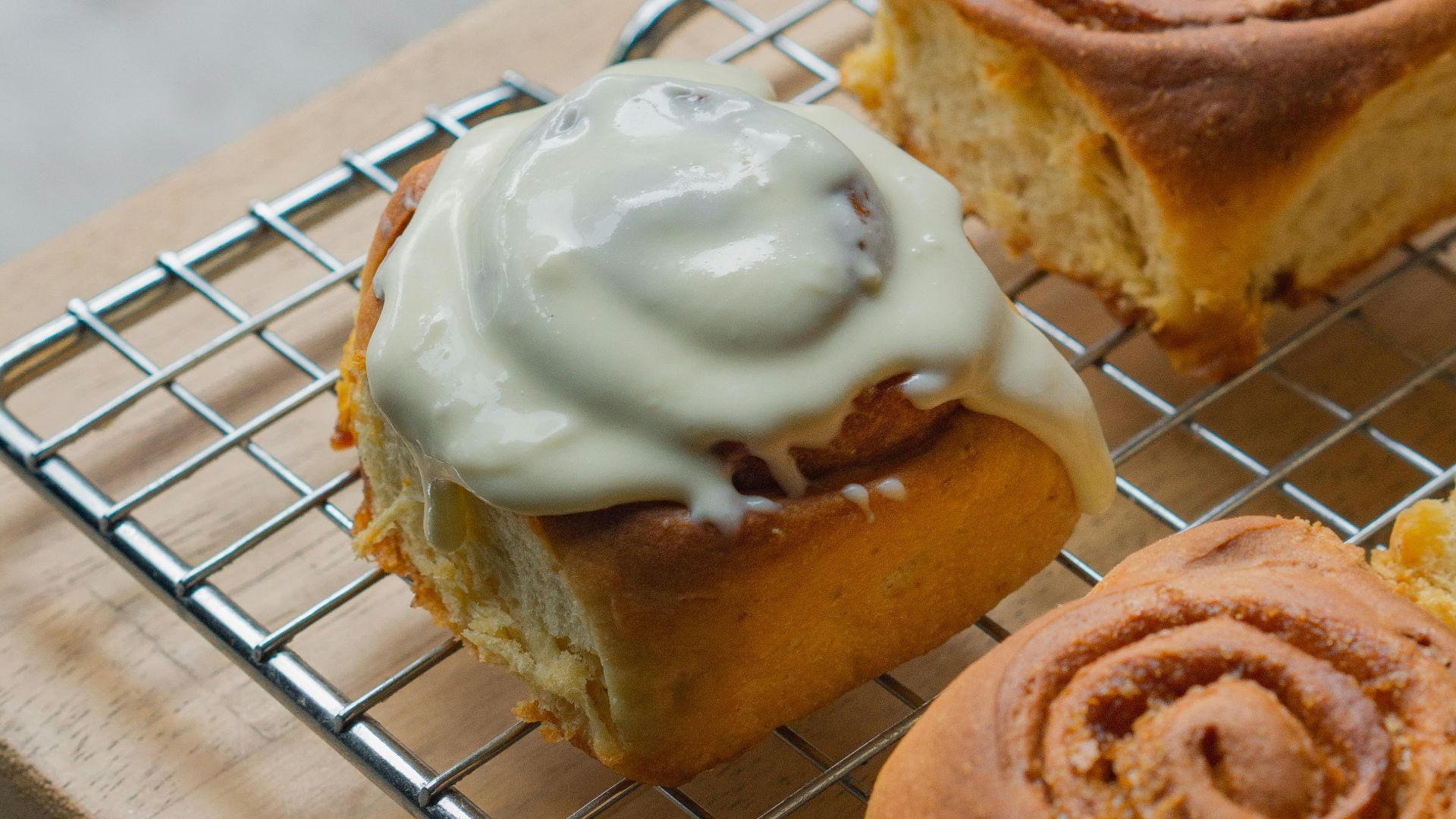 a metal rack holding pastries on top of a wooden table