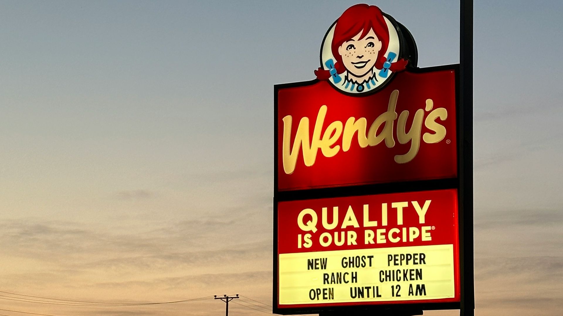 a sign for wendy's restaurant in a parking lot