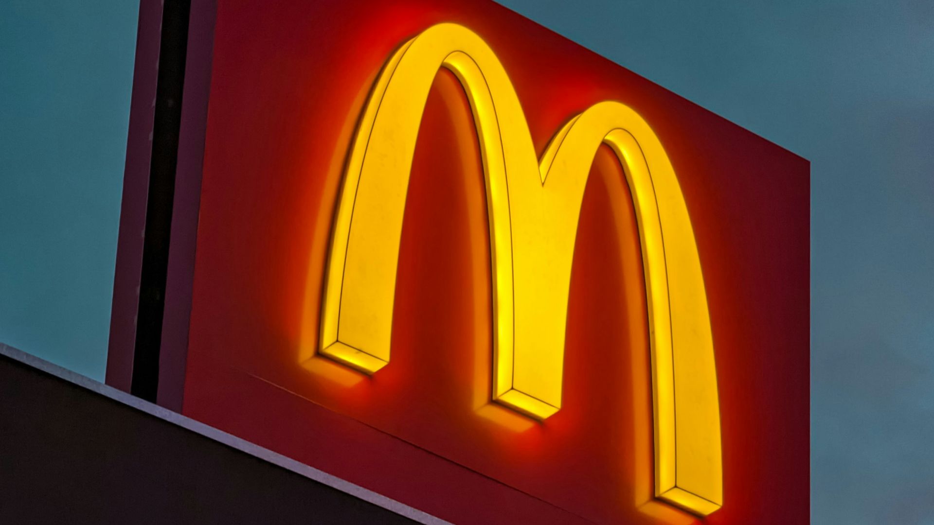 a mcdonald's sign lit up at night