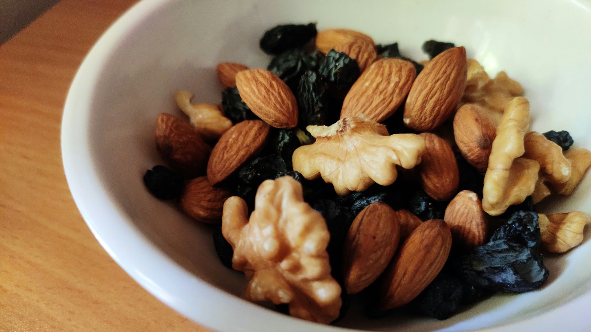 brown and black nuts on white ceramic bowl