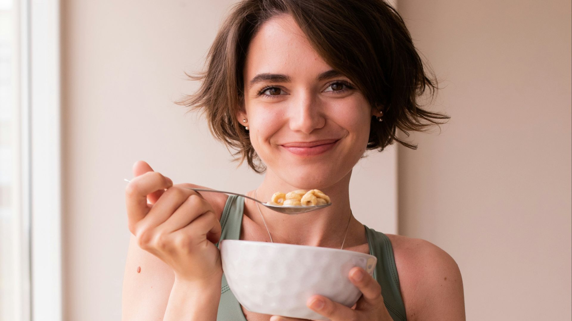 a woman in a sports bra top holding a bowl of food