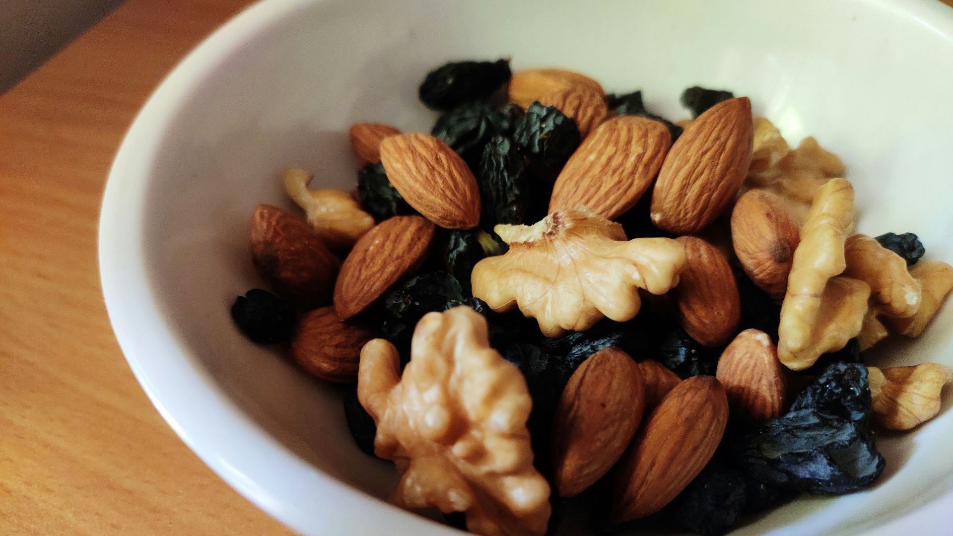brown and black nuts on white ceramic bowl