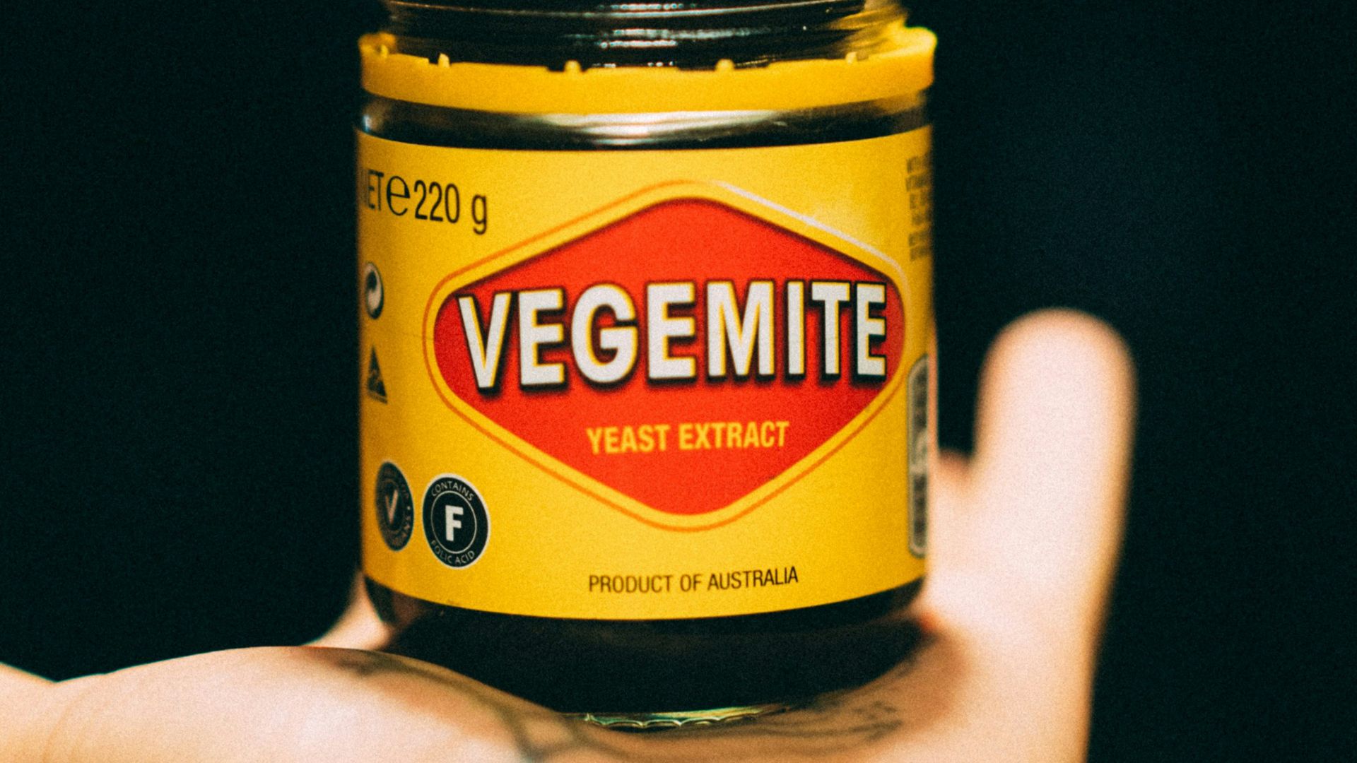 person holding yellow and black bottle