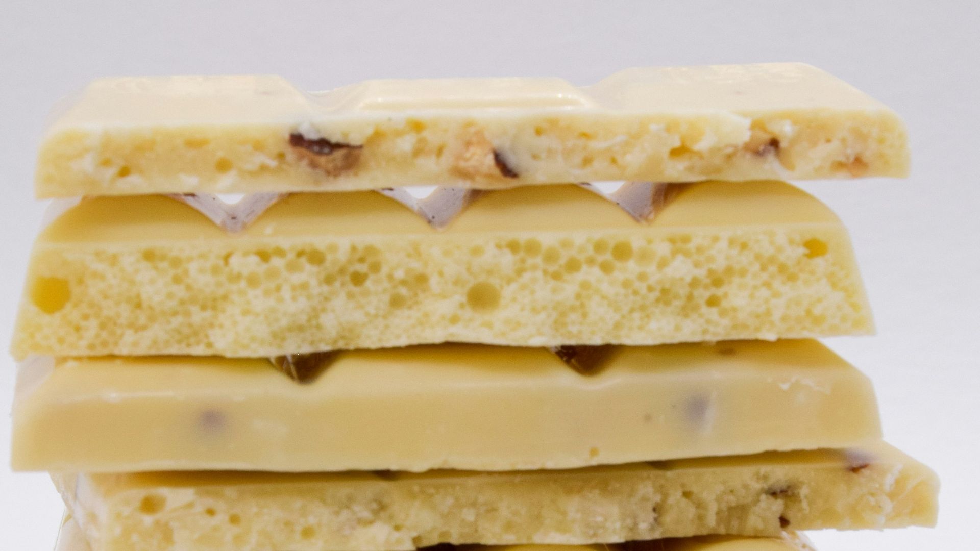 a stack of four pieces of food on a white surface