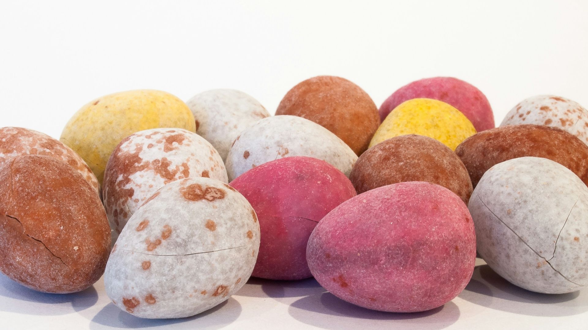 a pile of different colored rocks on a white surface