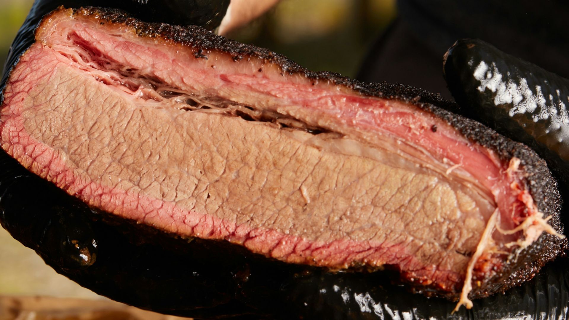 person holding raw meat during daytime