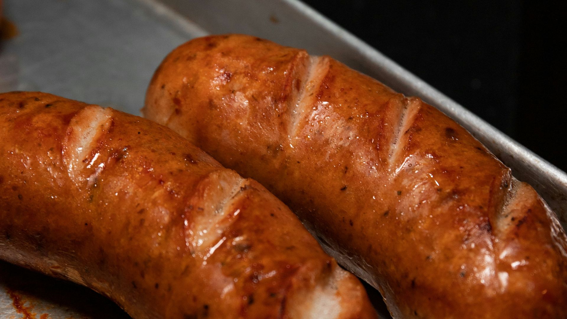 brown sausage on stainless steel tray