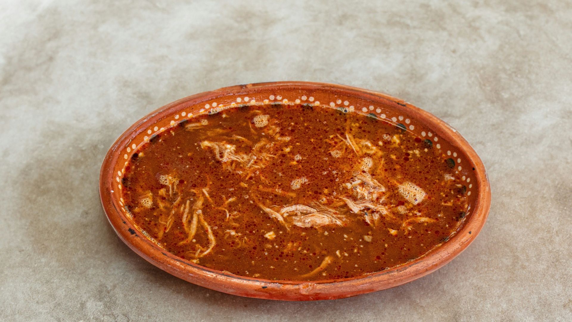 A small orange bowl sitting on top of a table