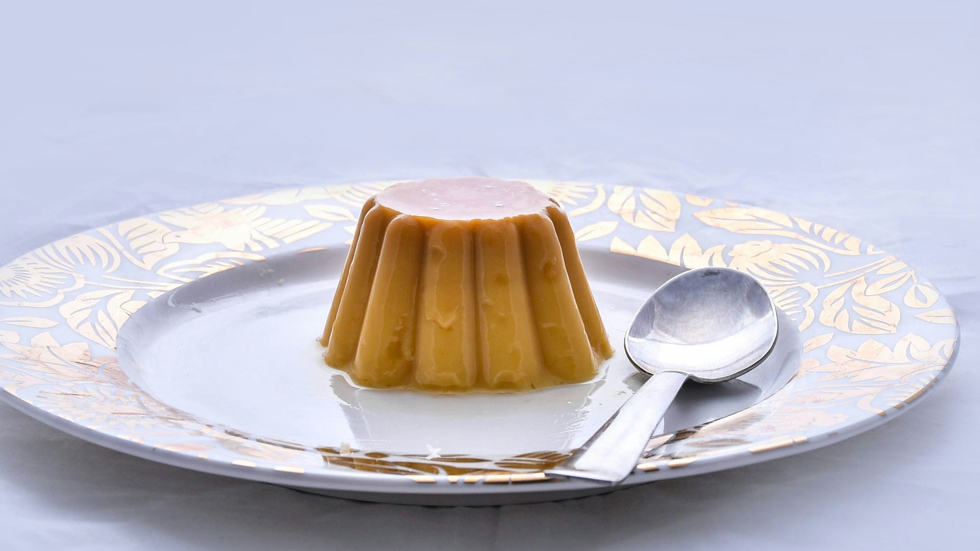 brown and white ceramic saucer with stainless steel spoon