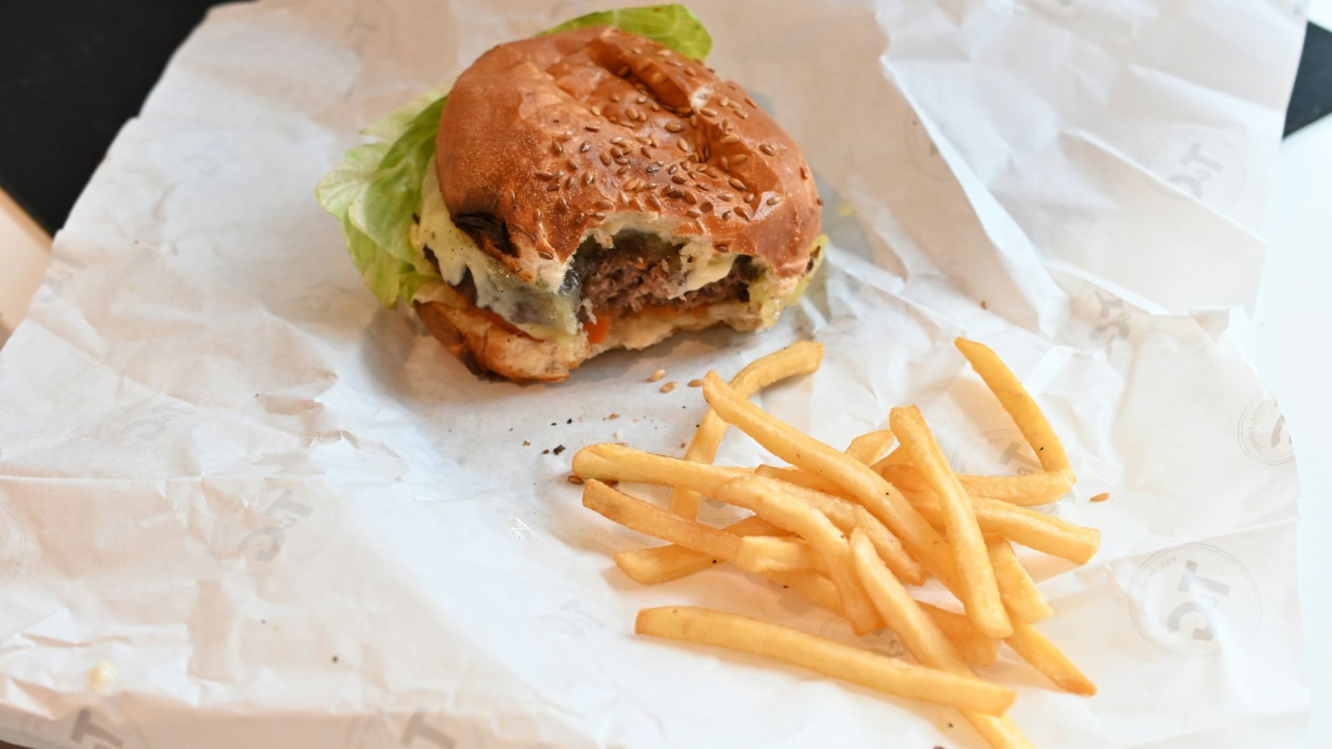 a hamburger and french fries sitting on a piece of paper
