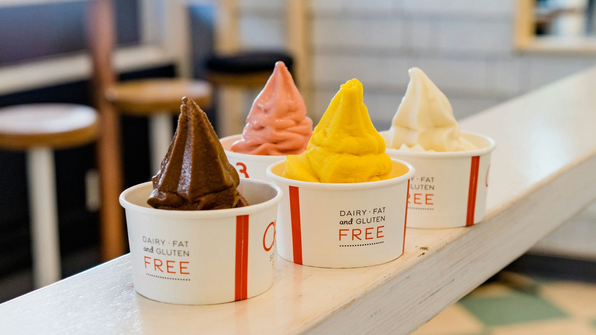 four assorted flavor of ice cream on white wooden table