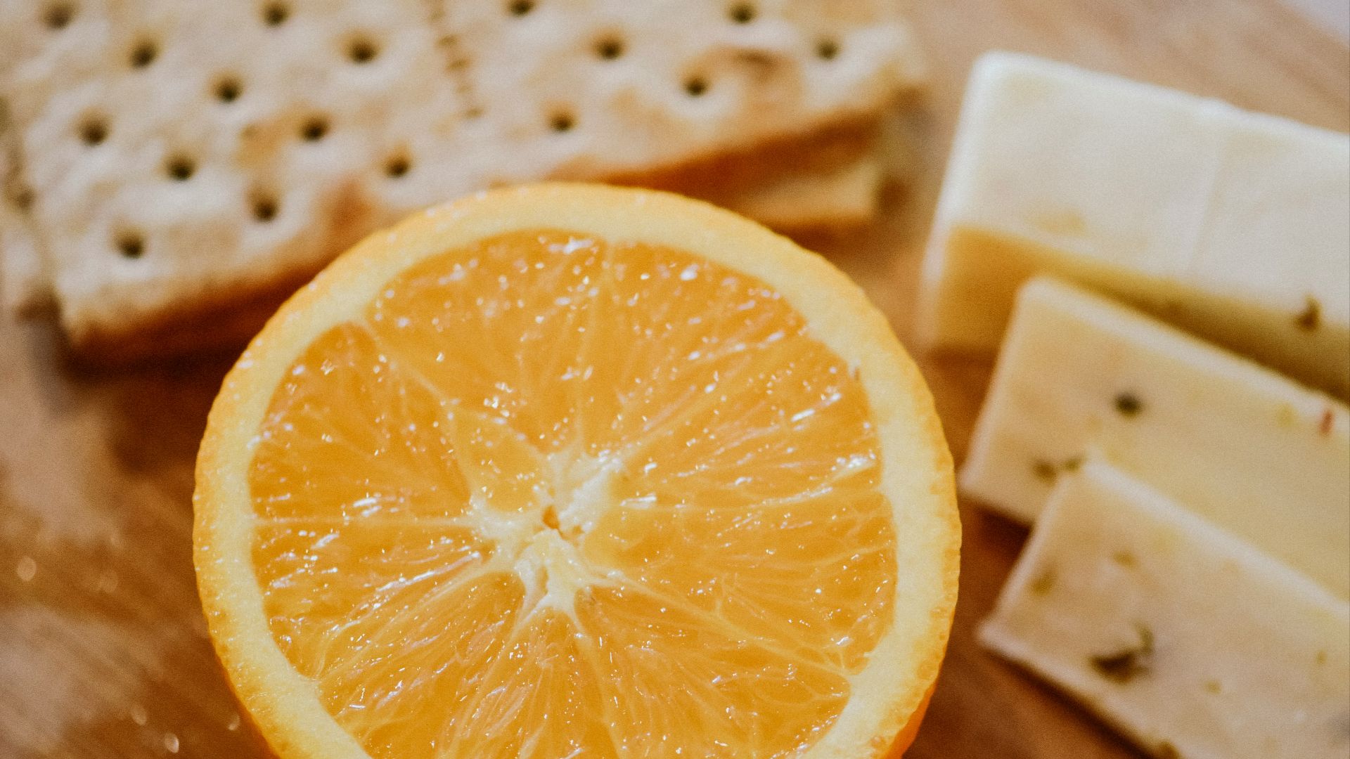 sliced orange fruit on brown wooden chopping board