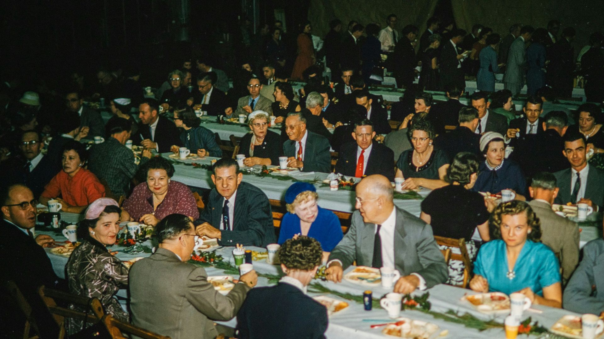 a large group of people sitting at tables eating food