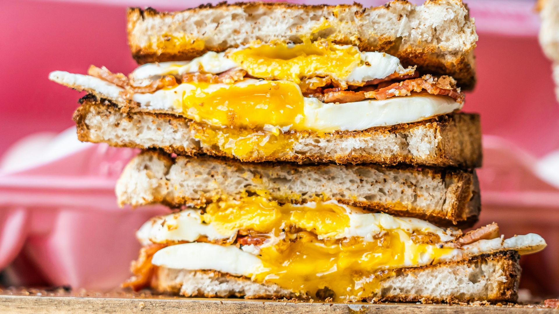 a stack of toasted sandwiches with eggs and cheese