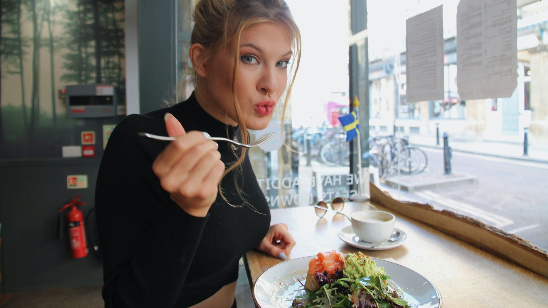 woman in black long sleeve shirt eating