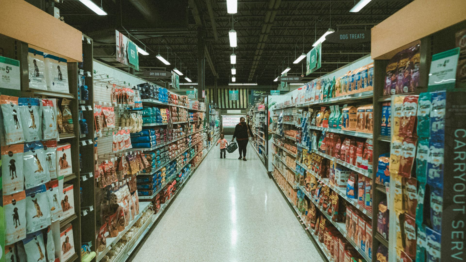 a person walking down a aisle in a grocery store