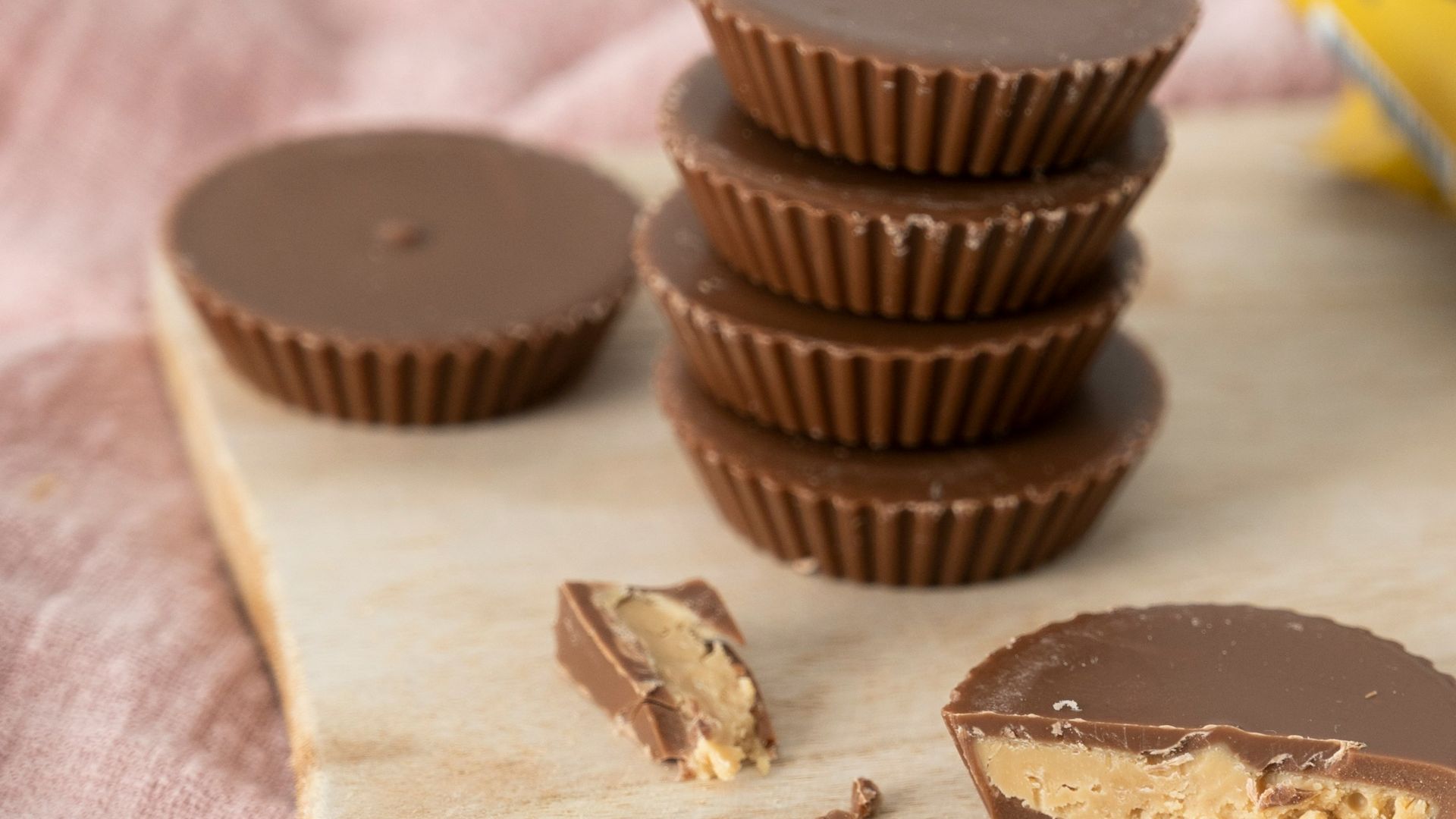 a wooden cutting board topped with chocolates and a cup of coffee