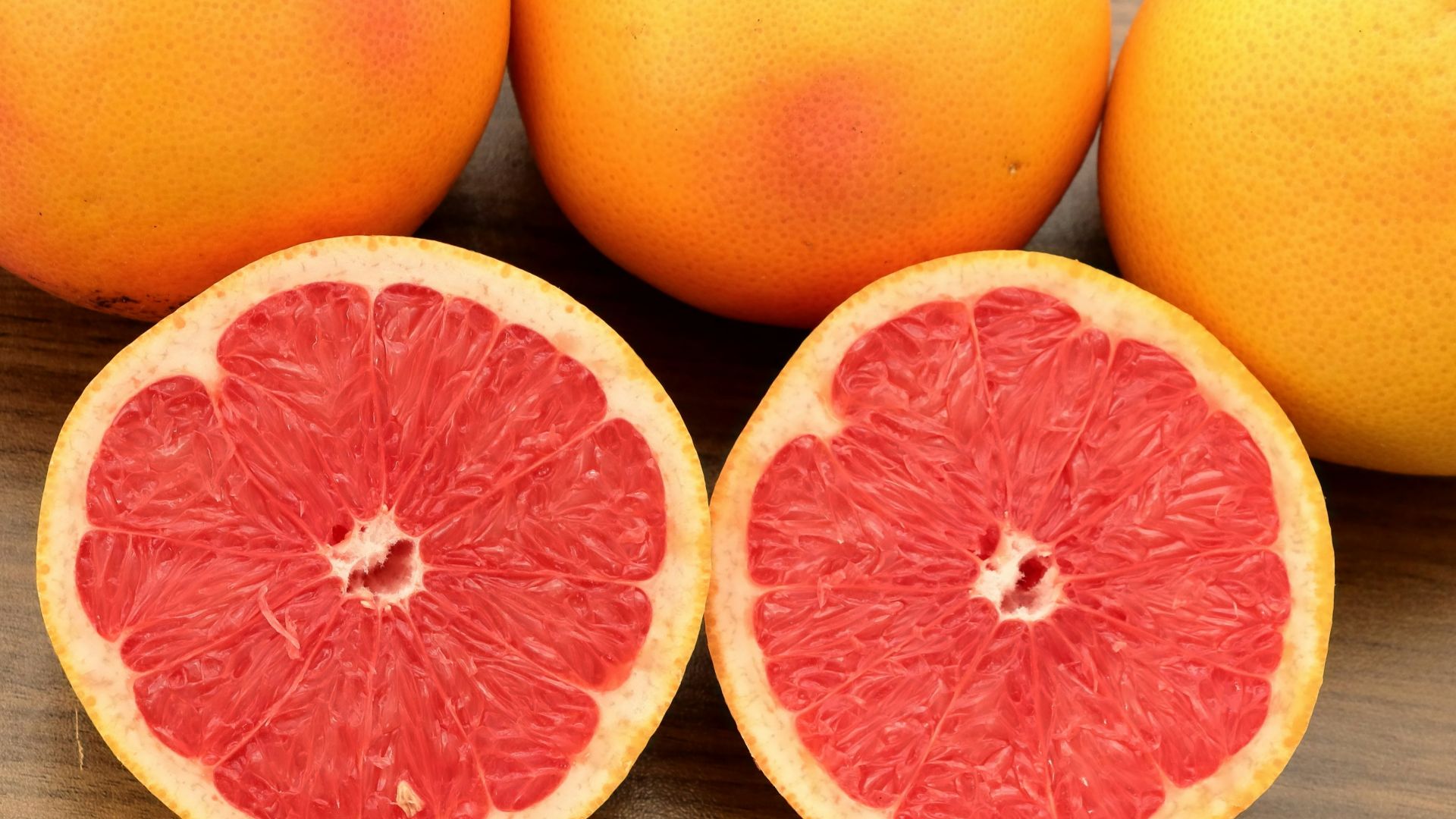 A group of grapefruits sitting on top of a wooden table