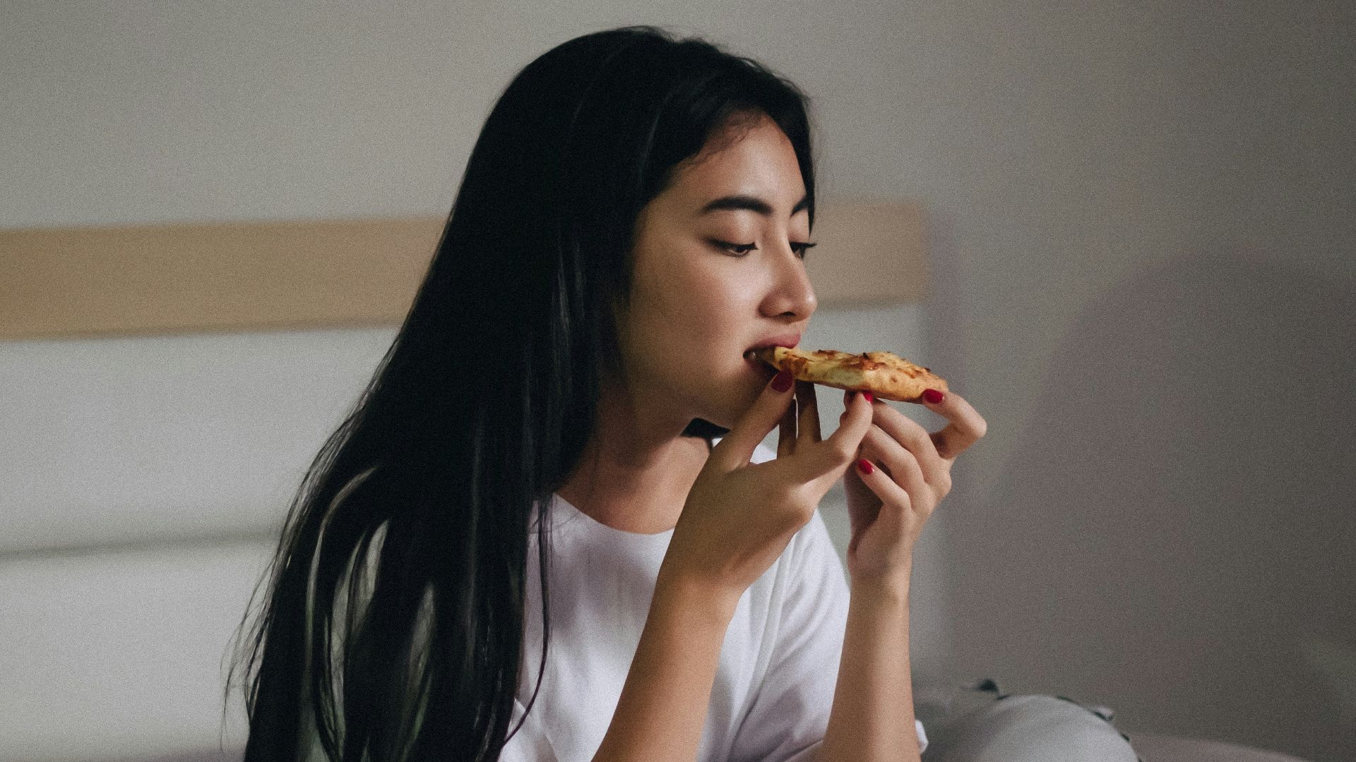 sitting woman in bed eating pastry