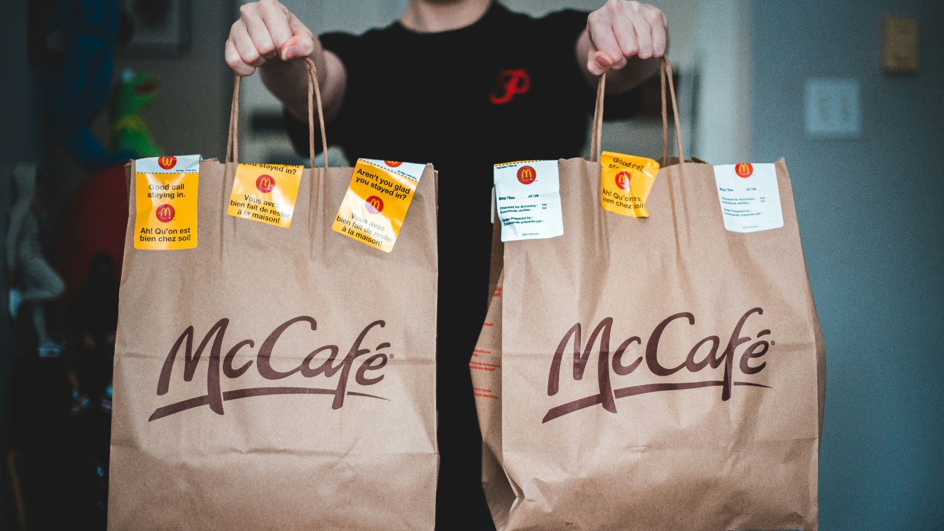 person holding white and brown tote bags