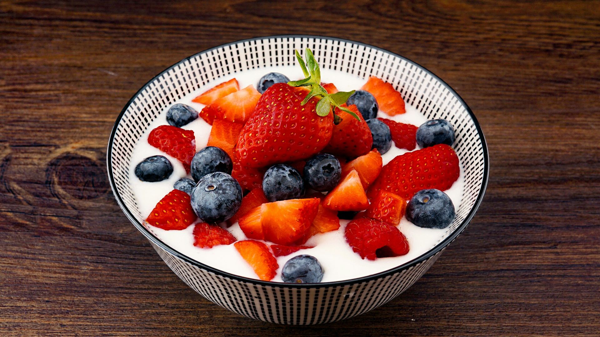 strawberry and blackberries on top of brown table