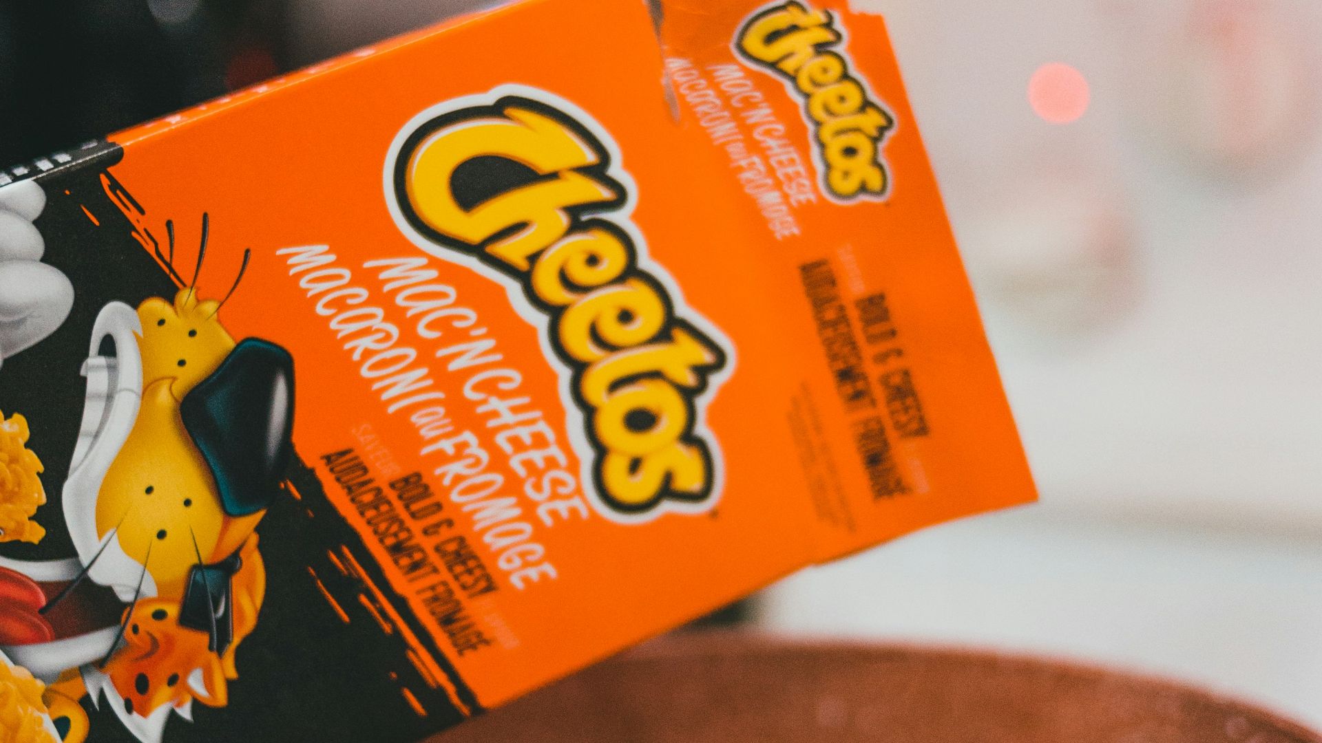 person holding orange and yellow box