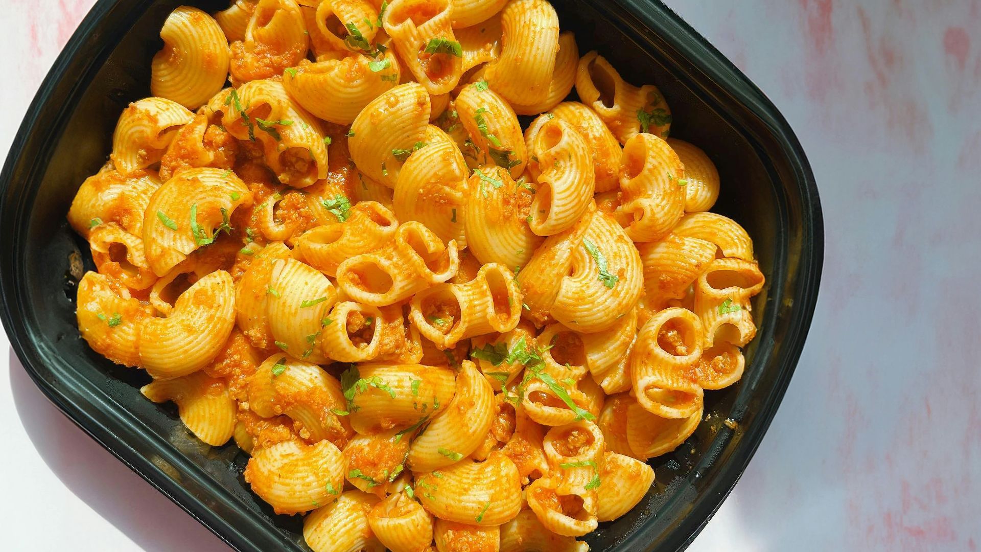 a black bowl filled with macaroni and cheese