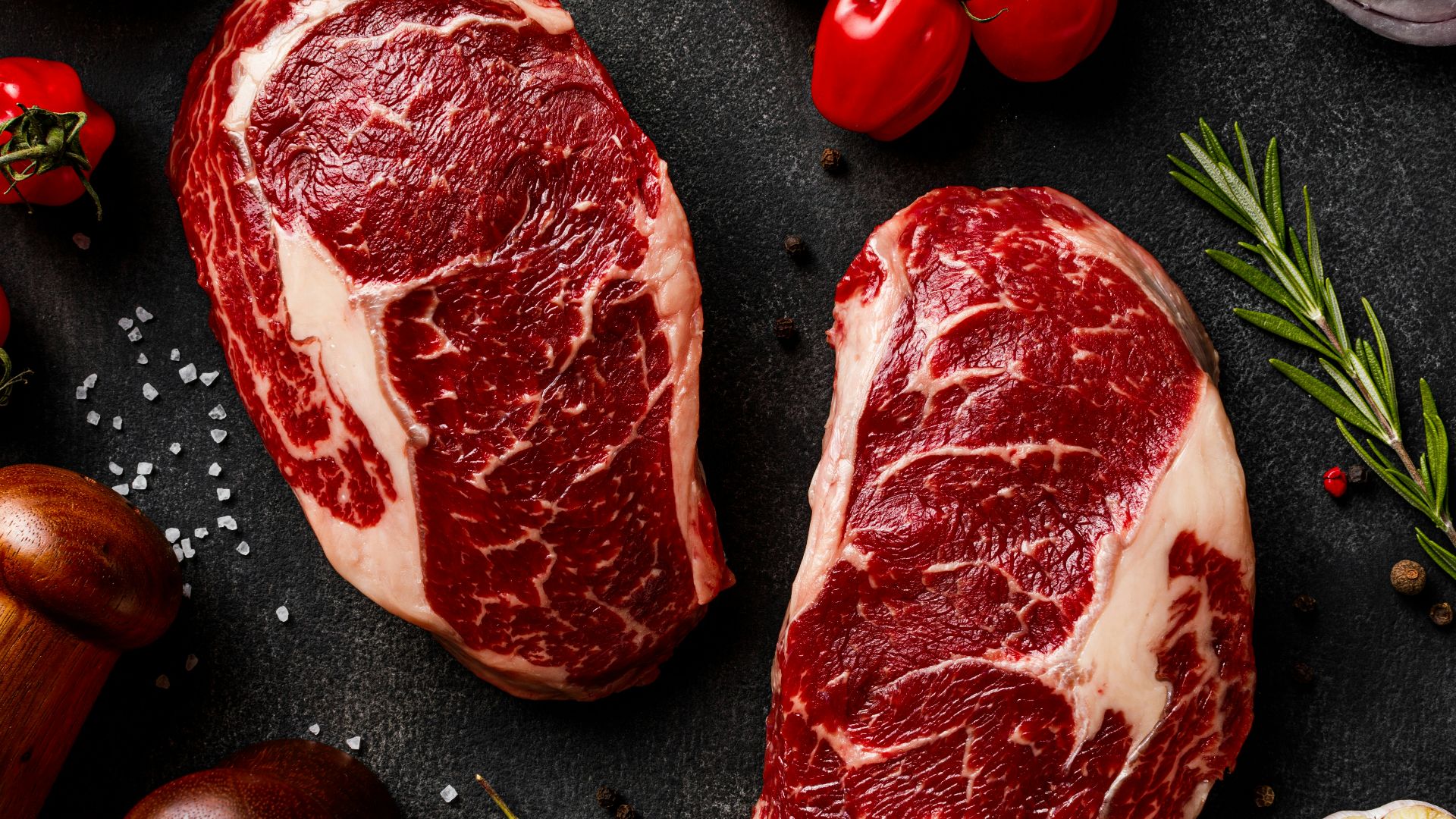 a couple of steaks sitting on top of a table