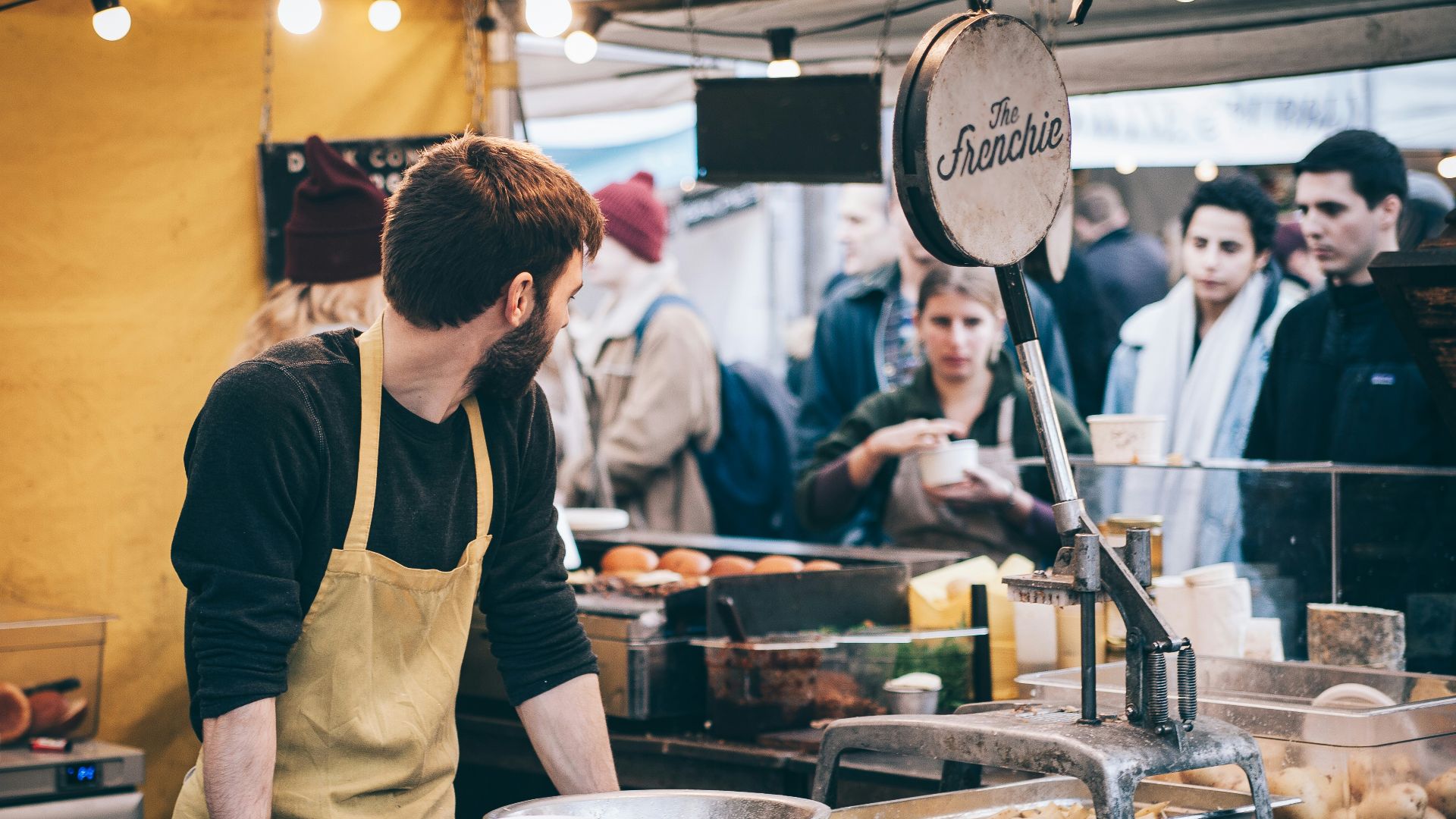 man leaning hand on table looking on group of people