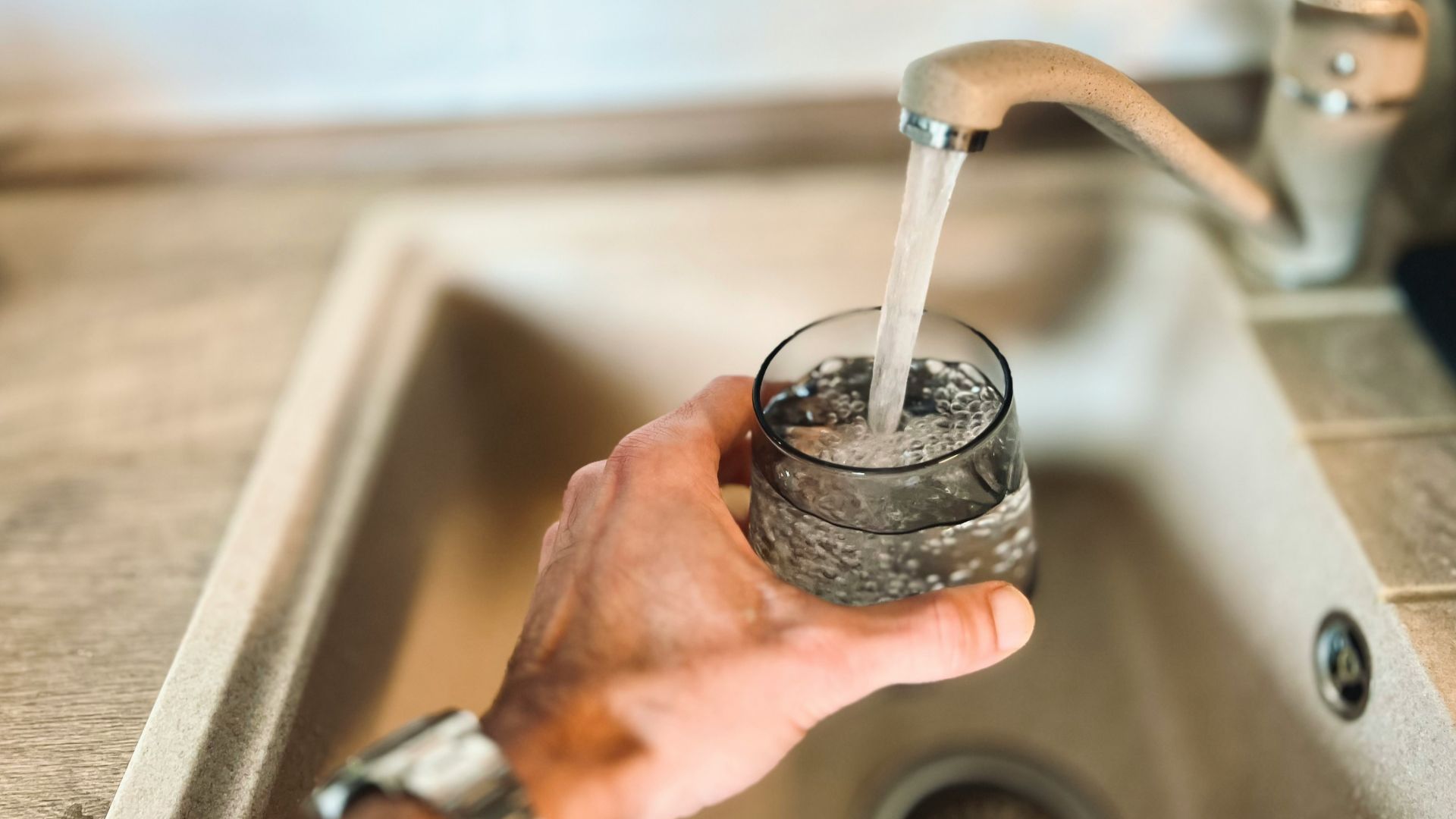a hand holding a glass of water