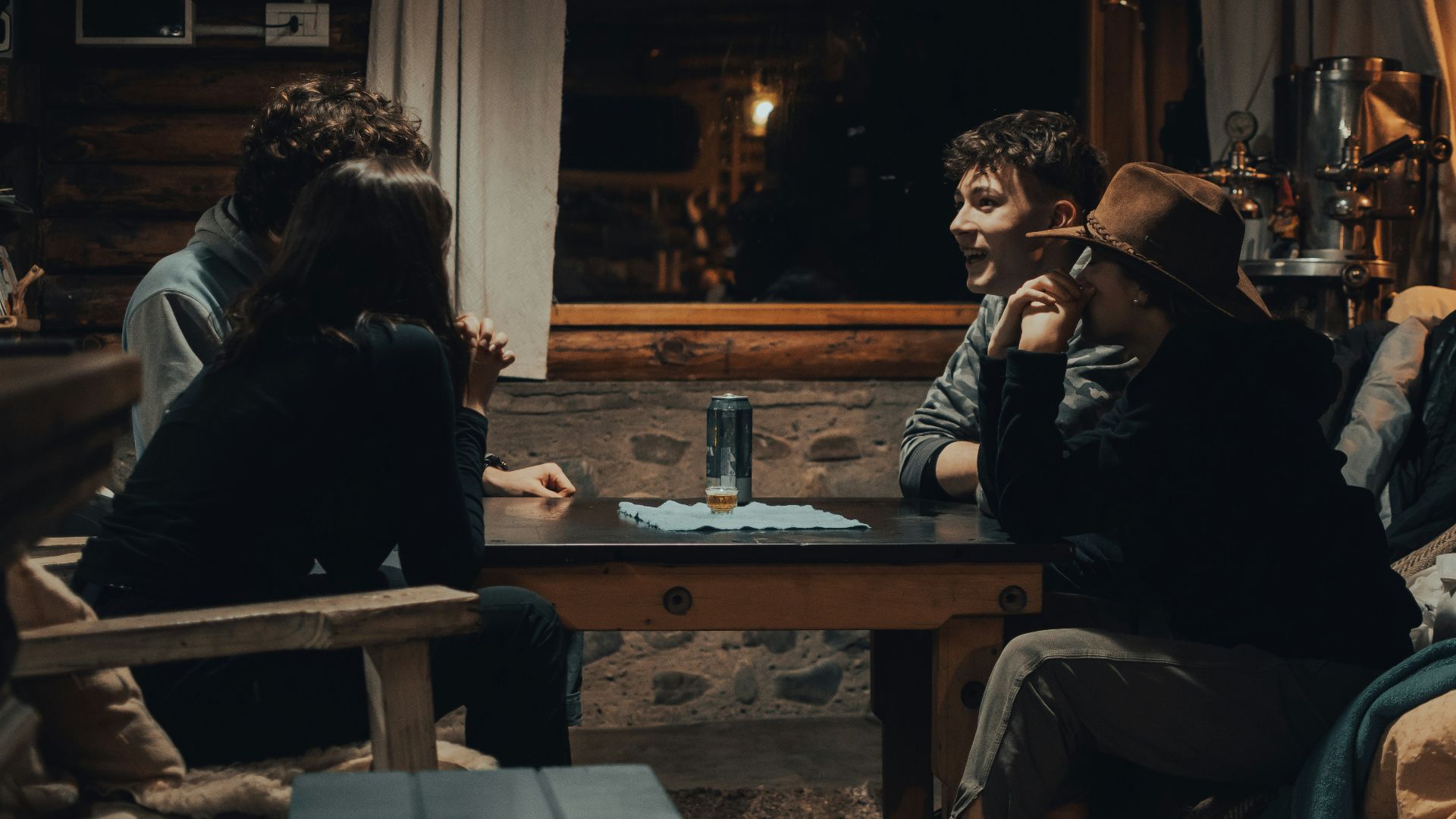 man in black jacket sitting on brown wooden chair