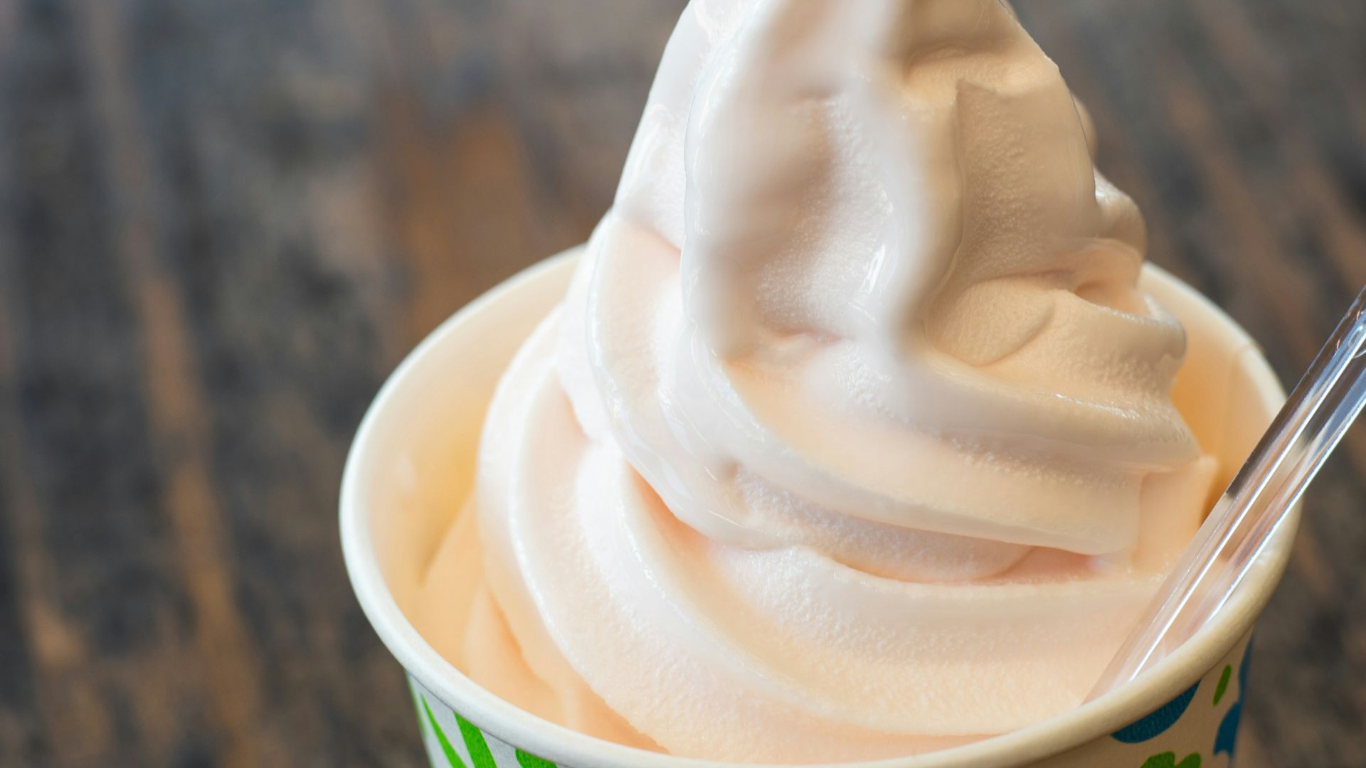 A cup filled with whipped cream on top of a wooden table