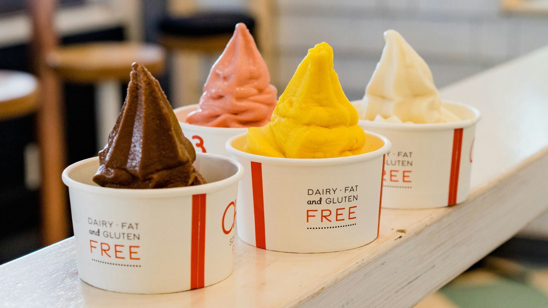 four assorted flavor of ice cream on white wooden table
