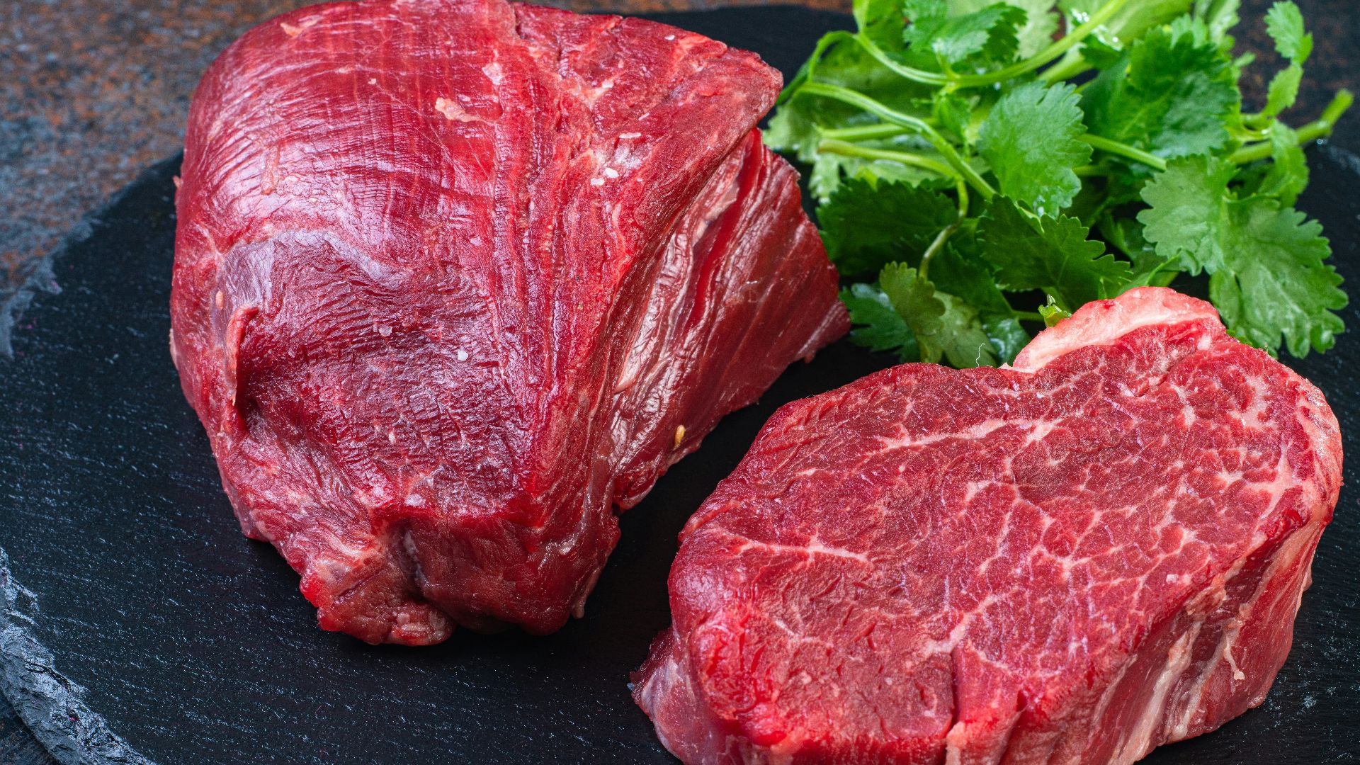 Two steaks on a plate with parsley