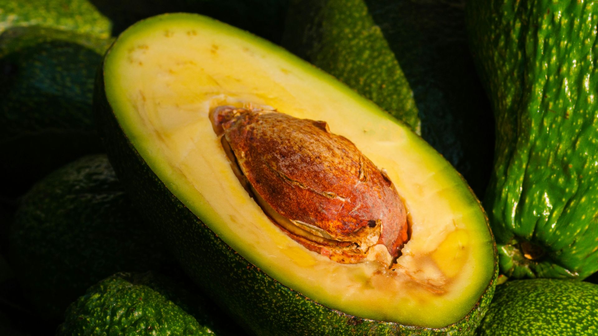 a pile of green avocados sitting on top of each other